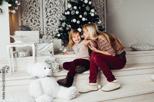Front View Of Cute Family Sitting Together On Stairs Looking At Camera And Smiling At Christmas Beautiful Mother And Child Hugging Big White Teddy Bear Concept Of New Year Atmosphere Buy