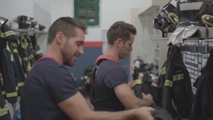 Wall Mural - Two firefighters prepare for the uniform to work.