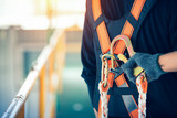 Fototapeta  - Construction worker wearing safety harness and safety line working at high place
