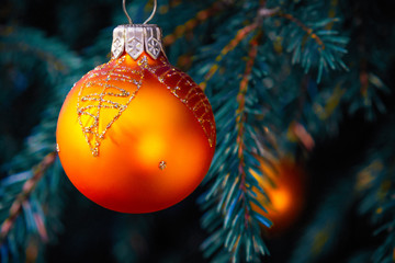 Orange balls on spruce, part of the Christmas tree with Christmas decorations