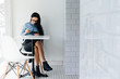 © mnelen.com - busy young brunette girl in blue shirt sits in cafe and looks at tablet