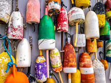 Colorful Lobster Buoys Hang On The Outside Wall Of A Fishing Shack, In Maine