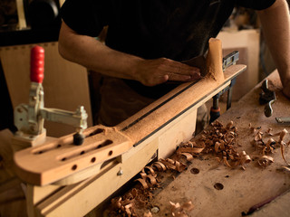 The guitar master makes a guitar neck.