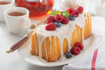 Wall Mural - Butter vanilla cake for breakfast with glaze and fresh berries.