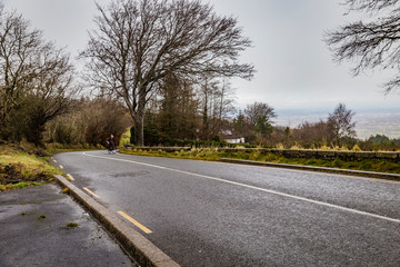 man riding a bike up a hill