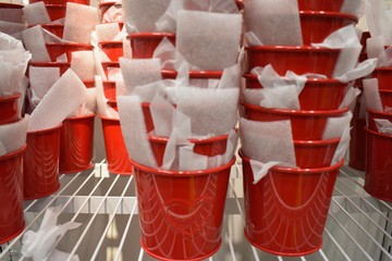 Red flower metal pots for christmas time, in ikea store, sweden