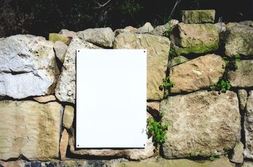 Blank white sign on a rural stone wall in the coutryside