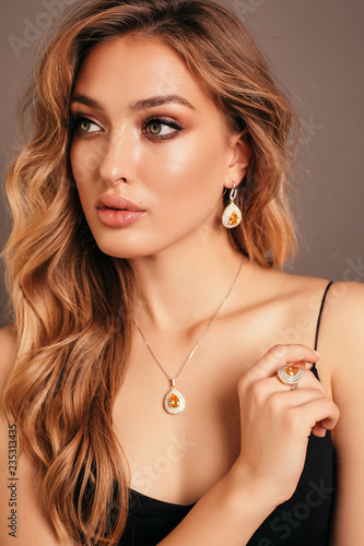 Fotografía beautiful woman with blond curly hair in elegant dress and jewelry accessories