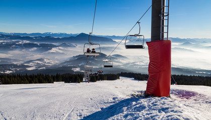 Skiers on the chairlift. Ski trails