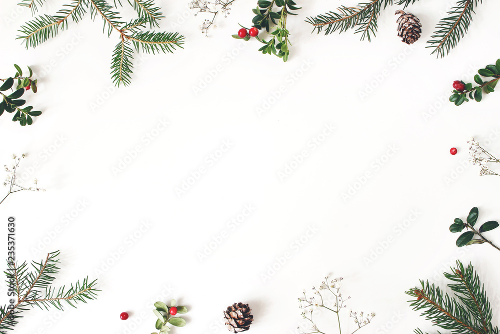 Christmas floral frame, decorative border. Winter composition of red cranberry branches, baby's breath flowers, spruce tree branches and larch cones on white table. Festive background. Flat lay, top - obrazy, fototapety, plakaty 