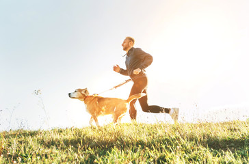 Wall Mural - man runs with his beagle dog. morning canicross exercise