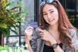 © kaew6566 - Smiling young woman holding a credit card and point fingers with sunglasses in garden background. Attractive business woman get satisfy and happy with freedom of payment.