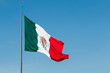Giant waving flag of Mexico with a blue sky.