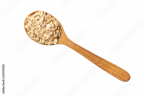 Fotografía Uncooked oatmeal in wooden spoon isolated on white top view