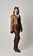 © faestock - full length portrait of brunette  girl wearing brown leather steampunk outfit. standing pose, on grey studio background.
