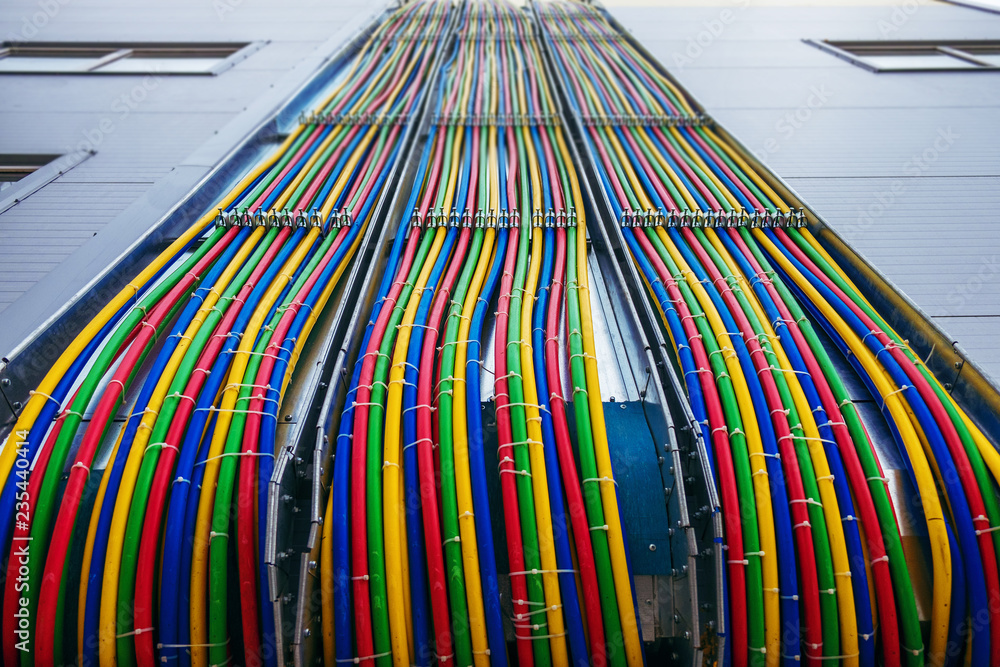 Different bright colors electric wires installed on the constructions of industrial building.
