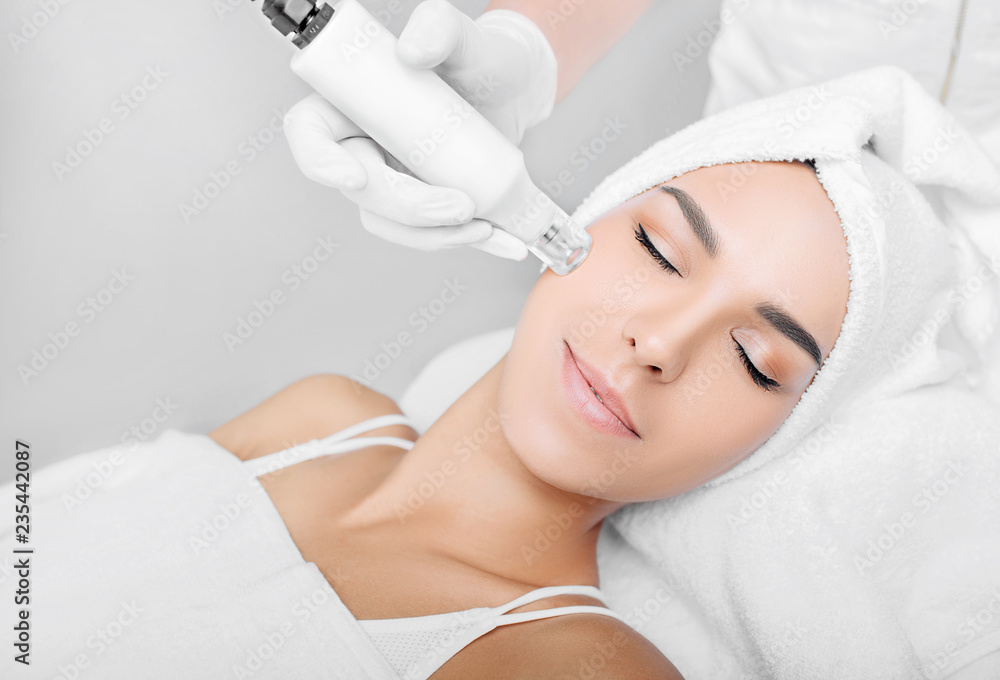 woman receiving no-needle high frequency mesotherapy at beauty salon. non-invasive procedure for skin rejuvenation - obrazy, fototapety, plakaty 