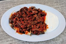 Turkish Iskender Kebap, Prepared From Thinly Cut Grilled Lamb Topped With Hot Tomato Sauce Over Pieces Of Pita Bread And Slathered With Melted Butter And Yogurt In Mugla, Turkey