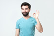 © Viktor Koldunov - Gesturing OK sign. Cheerful hispanic young man in t-shirt showing approving sign. Good choice concept
