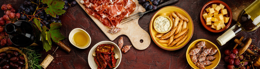 Wine and tapas on red vintage background, top view