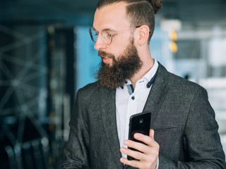 Wall Mural - project manager in suit jacket holding mobile phone. business lifestyle