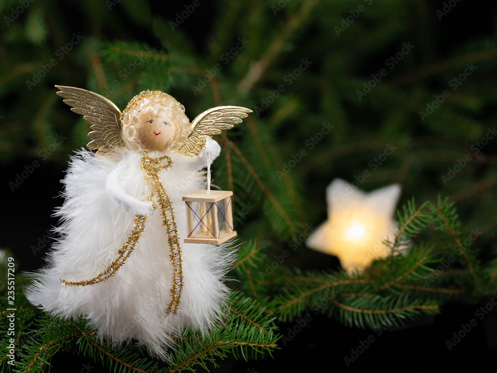 Engel mit Laterne vor angedeutetem Weihnachtsbaum mit Stern, handgearbeitet aus Federn Stock Photo