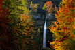 Autumn landscape in Slovenia, nature in Europe.  Pericnik waterfall, Triglav Alps with orange forest, travel in Slovenia. Beautiful sunset with waterfall. Art view on wild nature.