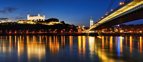 Canvas Print - BRATISLAVA, SLOVAKIA - May 5th, 2018: Panoramic view to Bratislava castle, SNP Bridge, Hotel Devin and St. Martin cathedral across Donau in the evening