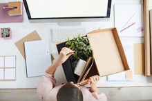 Top View Of New Employee By Workplace Unpacking Box With Business Stuff