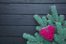 Fir Tree Branch With A Pink Heart On A Black Background.