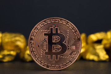 Closeup of bitcoin digital currency and gold nugget or gold ore on black background, precious stone or lump of golden stone, Cryptocurrency money financial and business concept.