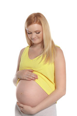 Poster - Beautiful pregnant woman showing her tummy on white background