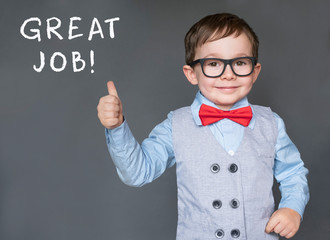 cute little boy giving thumbs up saying great job