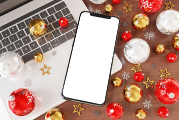 Wall Mural - Mobile phone laying on laptop with christmas baubles mockup 3d rendering