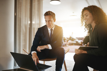 Two diverse businesspeople working on a laptop in an office