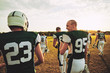 American football teammates walking off a laying field after pra