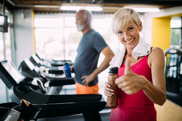 Wall Mural - Senior people running in machine treadmill at fitness gym club