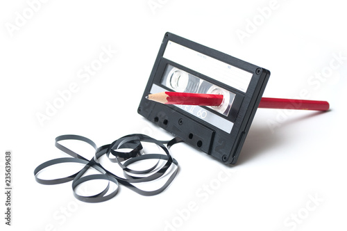 Fotomural closeup of vintage audio cassette with magnetic band outside rewound with red pe