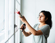 © Rawpixel.com - Woman using a silicone gun to repair a window