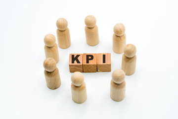 Wooden figures as business team in circle around acronym KPI Key Performance Indicator