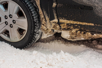 Car tires on winter road covered with snow. Vehicle on snowy alley in the morning at snowfall