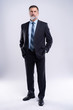© opolja - Full length portrait of confident mature businessman in formals standing isolated over white background.