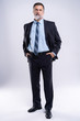 © opolja - Full length portrait of confident mature businessman in formals standing isolated over white background.
