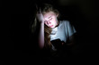 © Brian - Upset girl sitting in the dark while using her smartphone. The light from the screen is illuminating her face.