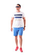 © sharplaninac - Serious macho man in summer t-shirt and shorts with sunglasses approaching and looking up with attitude. Full body isolated on white background.
