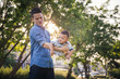 © sorrapongs - Father lifting son in hand and pretending to wheel with pleasure on blur background at garden, Lifestyle and Family Concepts
