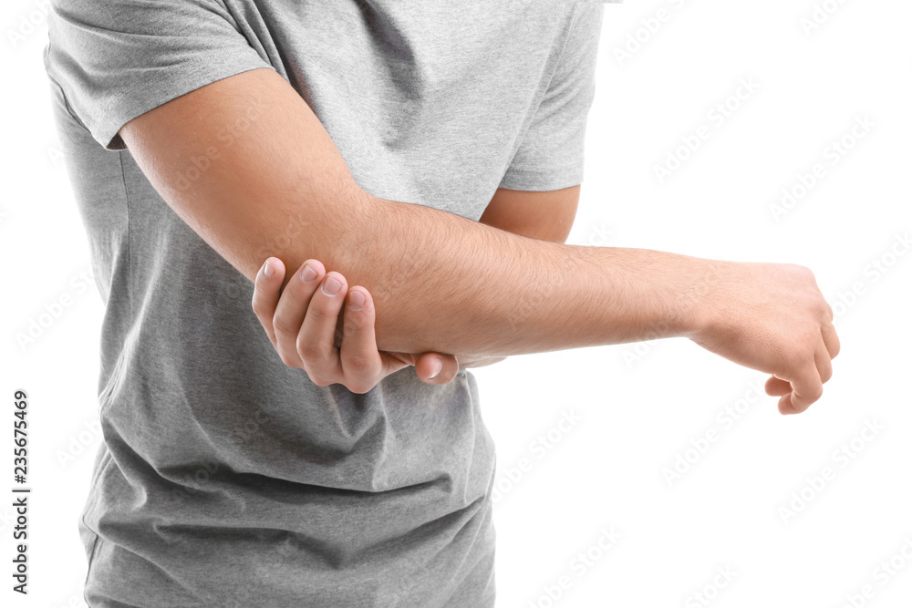 Young man suffering from pain in elbow on white background, closeup