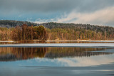 Fototapeta Las - Incredible reflections in the lake with beautiful sunset light. The first frosts in Scandinavia, Finland