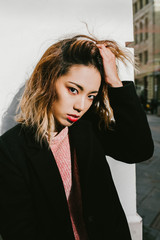 a girl of Asian appearance touches the hair on her head