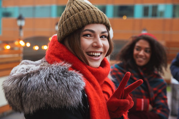 Wall Mural - Happy young friends talking with each other outdoors winter concept.